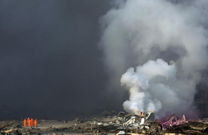 De la fumée continue de s'élever le 13 août 2015, un jour après l'explosion dans un entrepôt de produits chimiques à Tianjin, en Chine.