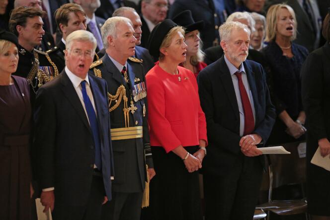 Jeremy Corbyn, en cravate rouge, garde la bouche close au milieu d’invités chantant 