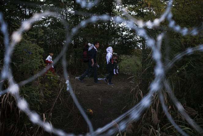 Une famille de réfugiés le long de la nouvelle clôture installée à la frontière entre la Hongrie et la Serbie, le 14 septembre.