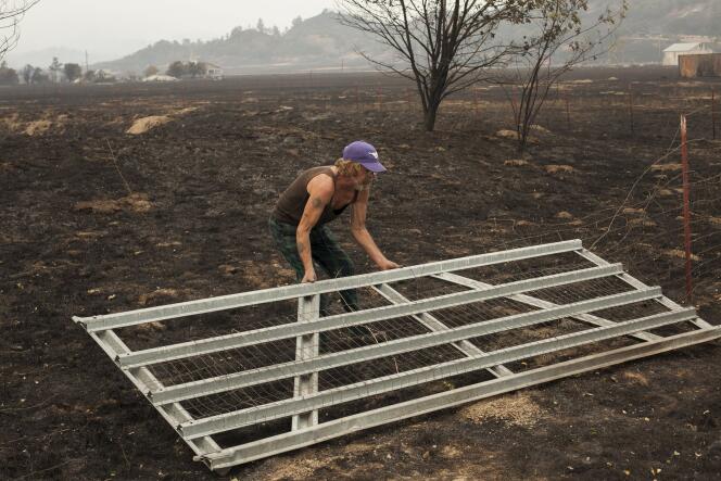Un homme redresse la barrière de sa propriété, brûlée par le 