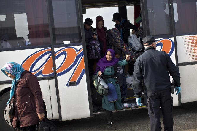 Des migrants descendent d'un bus arrivant de Serbie pour s'enregistrer dans le centre pour migrants d'Opatovac, du côté croate de la frontière, le 24 septembre.