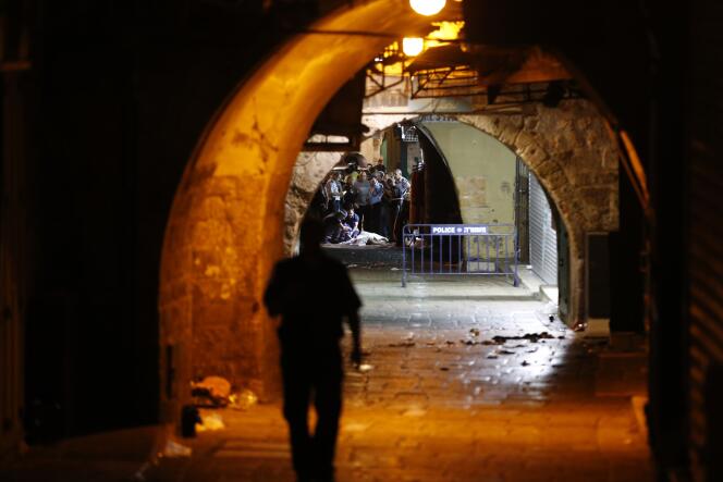 Les forces de sécurité israéliennes autour du corps de l'homme qui a attaqué quatre membres d'une même famille, samedi 3 octobre, à Jérusalem.