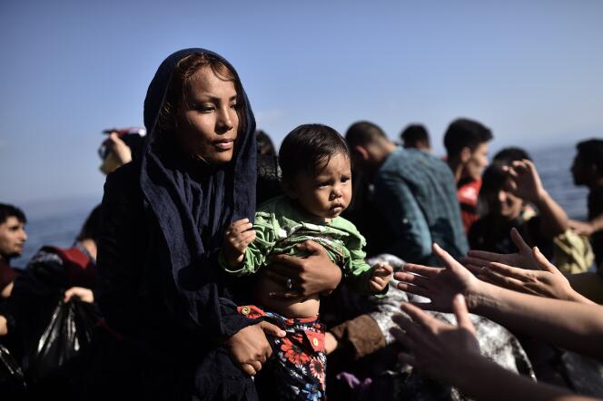 Une femme tient son enfant en arrivant à Lesbos, en Grèce, après avoir traversé la mer Egée.