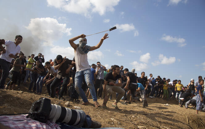 Un Palestinien lance une pierre sur des soldats israéliens à la frontière de la bande de Gaza, le 9 octobre.