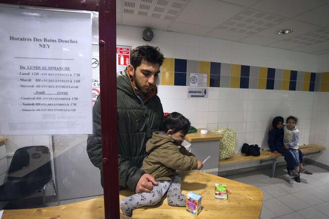 Un réfugié syrien et son enfant aux bains-douches, Porte de Saint-Ouen, à Paris, le 2 octobre.