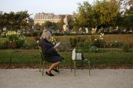 A woman reads a newspaper in the Jardin des Tuileries in Paris, France October 11, 2015. REUTERS/Kevin Coombs