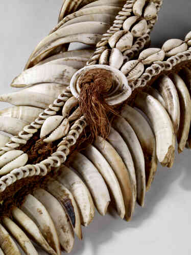 Ce pectoral – en forme de pointe – est composé de rangées de dents de cochons taillées et de dents de chiens fixées sur un bandeau de fibres tressées orné de coquillages.