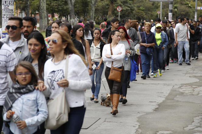 Citoyens colombiens faisant la queue devant un bureau de vote, dimanche 25 octobre à Bogotá.