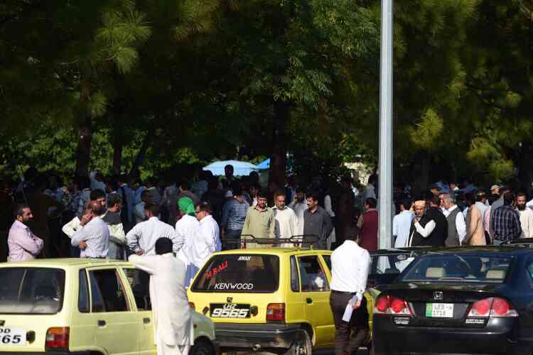 Des habitants d'Islamabad attendent dans une rue, après le tremblement de terre.