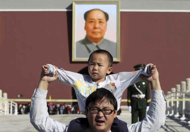 Devant le portrait de Mao Zedong, sur la place Tiananmen, à Pékin.