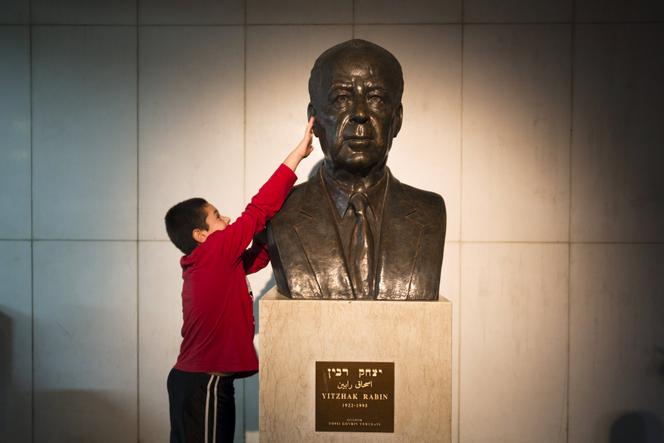 Un garçon israélien touche le buste de l’ancien premier ministre Yitzhak Rabin avant un rassemblement commémorant le 20ᵉ anniversaire de son assassinat, à Tel Aviv, en Israël, le 31 octobre 2015. 