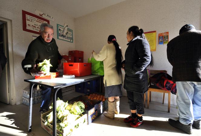 Un bénévole du Secours catholique distribue des colis de la Banque alimentaire, le 4 décembre 2009 à Saint-Eloy-les-Mines.