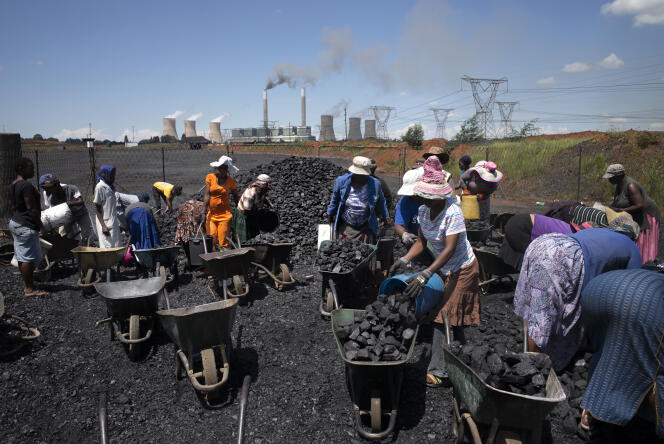L'Afrique du Sud est affectée par la diminution de la demande chinoise d'or, de platine, de fer et de charbon. Des femmes remplissent des brouettes près de la mine d'Emalahleni