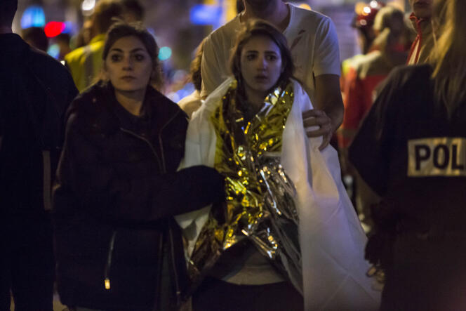 Des personnes blessées ou choquées quittent le lieu de l'attaque terroriste du Bataclan le 13 novembre 2015 à Paris.