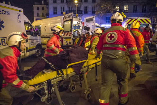 Des secouristes s'occupent des blessés, le 13 novembre 2015, boulevard des Filles du Calvaire, à Paris, à proximité de la salle du Bataclan dans laquelle se déroule au même moment une attaque terroriste.