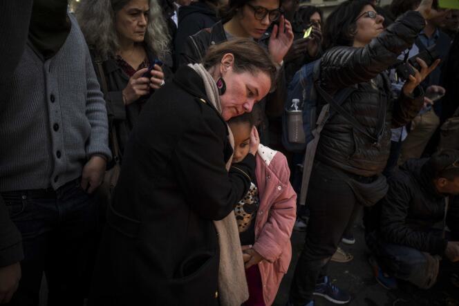 Une femme réconforte une enfant, le 15 novembre 2015 devant le restaurant 