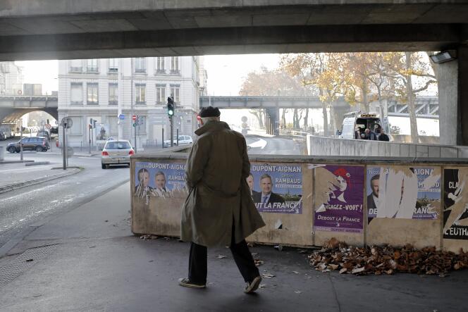Un homme passe devant des affiches électorales à Lyon le 3 décembre 2015.