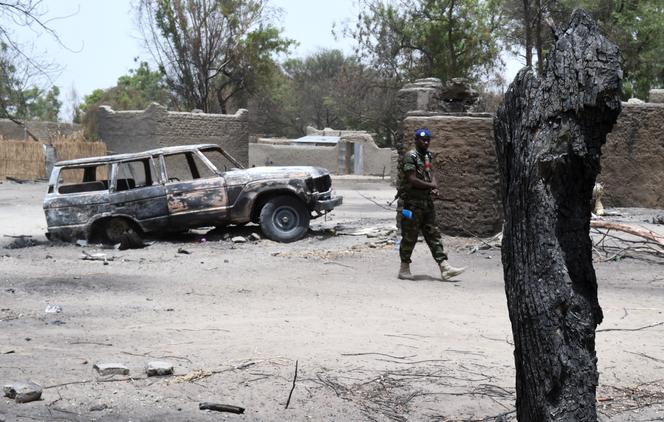 Un gendarme tchadien patrouille devant des maisons incinérées à N’Gouboua, près du lac Tchad, le 6 avril 2015.