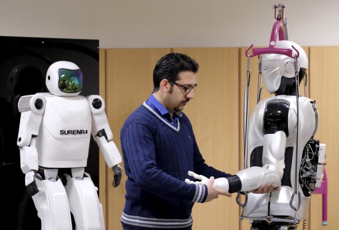 An engineer works on Surena 3 humanoid robot (R) next to Surena 2 robot, in a lab at Tehran University, Iran December 6, 2015. The University of Tehran has developed a humanoid robot that weighs 98 kg. It can navigate uneven terrain and detect faces. REUTERS/Raheb Homavandi/TIMA  ATTENTION EDITORS - THIS IMAGE WAS PROVIDED BY A THIRD PARTY. FOR EDITORIAL USE ONLY.