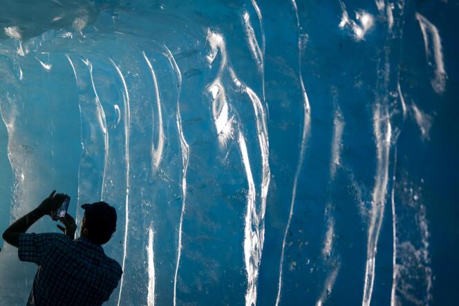 Un touriste photographie le glacier du Rhône près de Gletsch en Suisse.