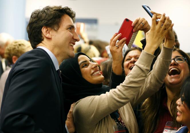 Canada's Prime Minister Justin Trudeau (L) poses with airport staff as they await Syrian refugees to arrive at the Toronto Pearson International Airport in Mississauga, Ontario, December 10, 2015. After months of promises and weeks of preparation, the first planeload of Syrian refugees was headed to Canada on Thursday, aboard a military plane to be met at Toronto's airport by Trudeau. REUTERS/Mark Blinch