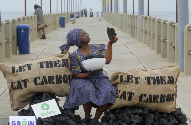 Busi Ndlovu, membre de l'ONG Oxfam, proteste contre l'utilisation du charbon de bois, sur une plage de Durban, en Afrique du Sud.