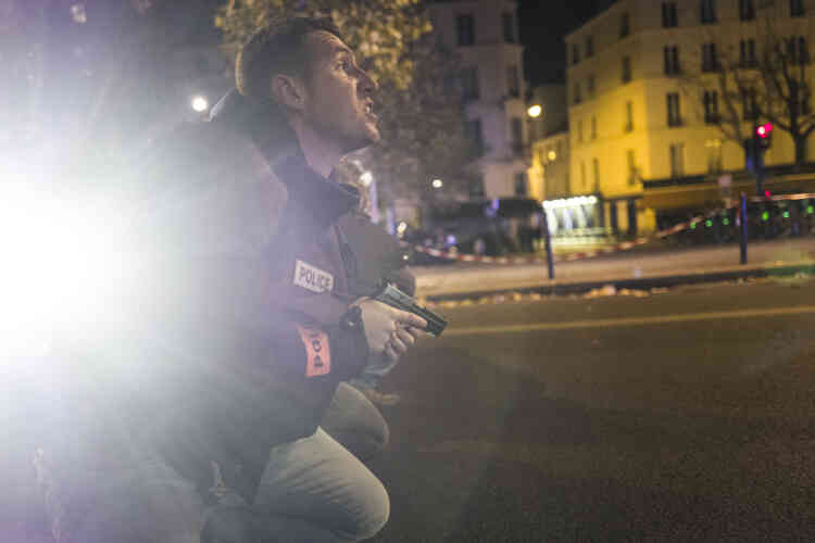 Paris, France, le 13 novembre. A cinq cents mètres du Bataclan, boulevard des Filles-du-Calvaire, les policiers se mettent à couvert tandis que des individus tirent dans leur direction.