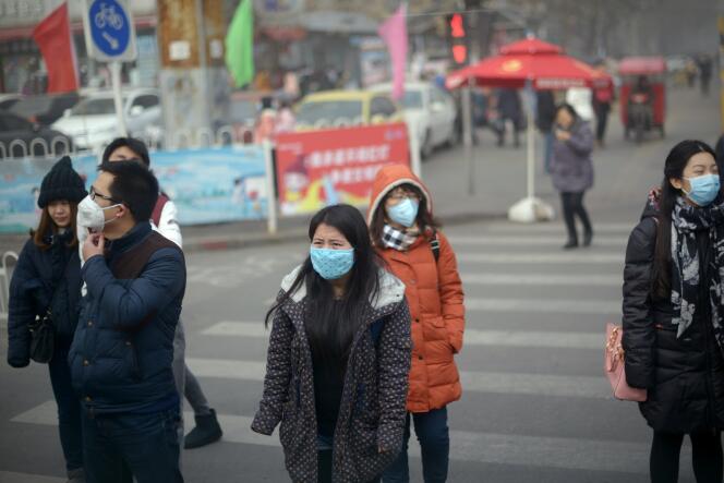 Dans une rue de Pékin, le vendredi 25 décembre. Le ciel est obscurci par un brouillard épais de pollution. Plus de 100 millions de personnes dans le pays étaient appelées à restés chez elles.