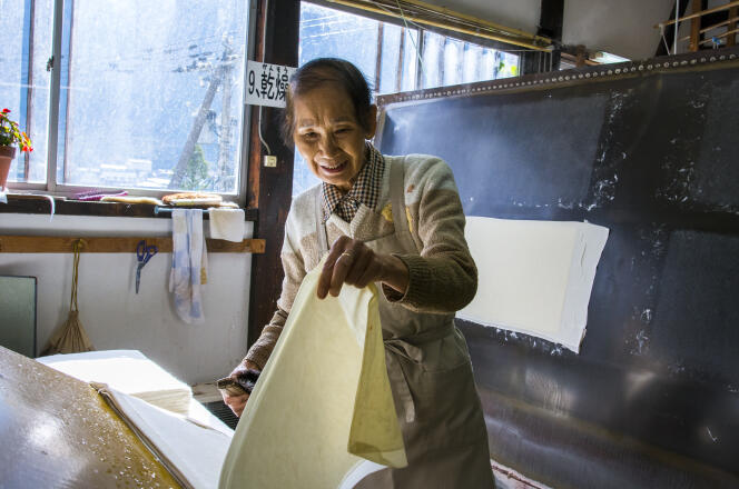 Mitsuko Yamaguchi décolle une à une les feuilles de papier japonais, dans la petite coopérative de Gokayama.
