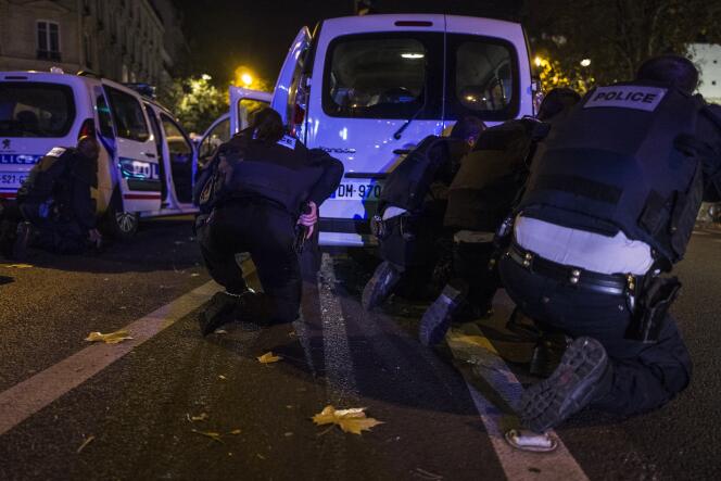 Des policiers se mettent à couvert tandis que des individus tirent dans leur direction, le 13 novembre 2015 boulevard des Filles du Calvaire à Paris, à 500 mètres de la salle du Bataclan dans laquelle se déroulait au même moment une attaque terroriste.