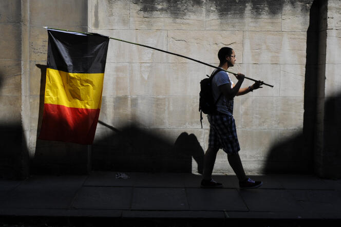 Un homme porte un drapeau belge le jour de la fête nationale à Bruxelles le 21 juillet 2013.
