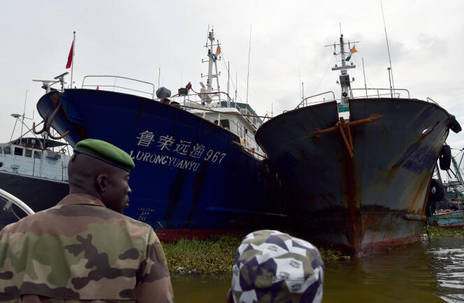 Garde-côtes ivoiriens au port d'Abidjan, où mouillent des chalutiers de pêche chinois en novembre 2014.
