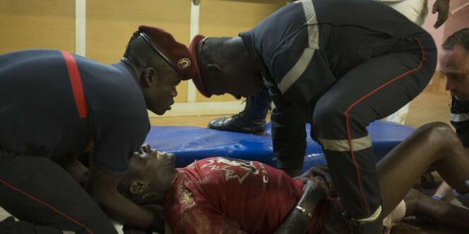 Des pompiers prennent en charge un blessé, à Ouagadougou, dans la nuit du 15 au 16 janvier.