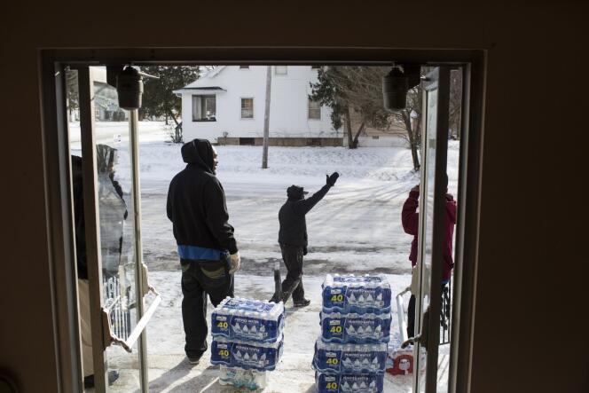Des volontaires distribuent des bouteilles d'eau minérale à la sortie d'une église de Flint, dans le Michigan, le 11 janvier 2016.