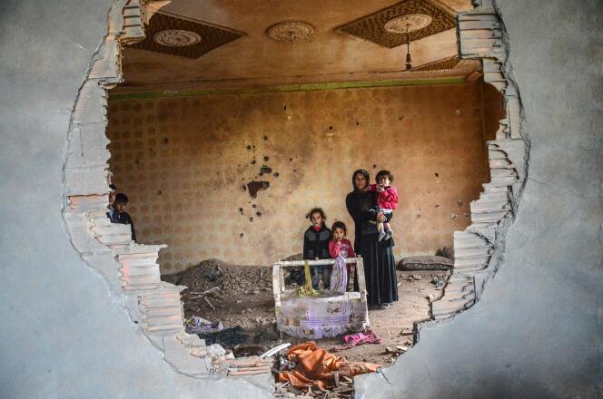 Une femme et ses enfants posent dans les ruines de leur maison détruite par les affrontements entre rebelles kurdes et forces turques, à Silopi (sud-est de la Turquie), le 19 janvier.
