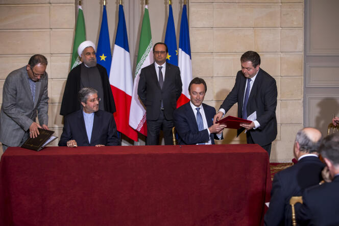 Le président d'Iran Air et Fabrice Brégier, PDG d'Airbus, signent un accord sous les yeux de François Hollande et du Président Iranien Hassan Rohani, à l'Elysée le 28 janvier 2016.