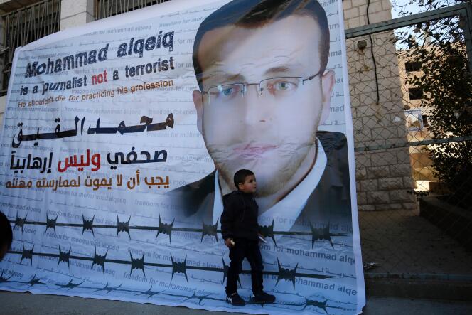 Islam, 3 ans, devant une affiche en soutien à son père Mohammed Al-Qiq, le 31 janvier 2016, à Ramallah.