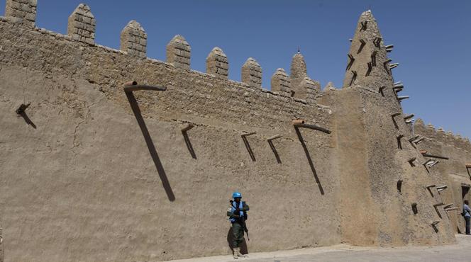 Un casque bleu de l'ONU devant la mosquée de Djingareyber à Tombouctou, au Mali, reconstruite notamment grâce à l'aide de l'Unesco. La cité est désormais interdite aux touristes français, par décision du Quai d'Orsay.