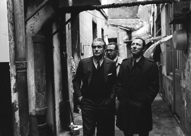 Prime Minister Jacques Chaban-Delmas (left) and Jacques Delors, advisor for social and cultural affairs (right), visit the inner courtyard of dilapidated housing in Paris (19th), February 2, 1970.