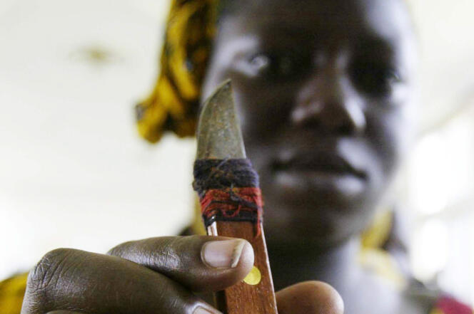 Une femme tient un outil utilisé pour exciser, lors d'un rassemblement pour dénoncer cette pratique de mutilation génitale à Abidjan en Cote d'Ivoire, en 2005.