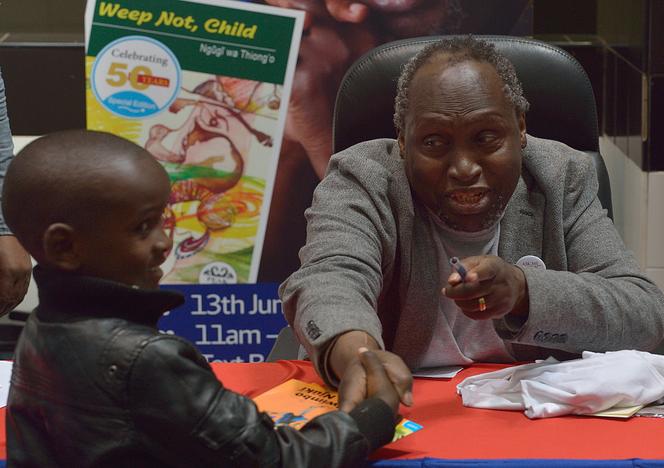 Ngugi wa Thiong’o serre la main d’un jeune admirateur le 13 juin 2015 lors d’une séance de dédicaces célébrant le jubilé d’or de son premier livre, « Weep Not, Child », à Nairobi, la capitale kenyane.