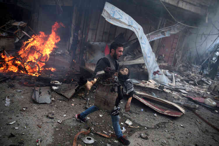 Deuxième prix, catégorie « Informations générales ». Un Syrien porte le corps sans vie d'un enfant, après un bombardement attribué à l'armée syrienne, dans la banlieue de Damas, le 7 novembre.