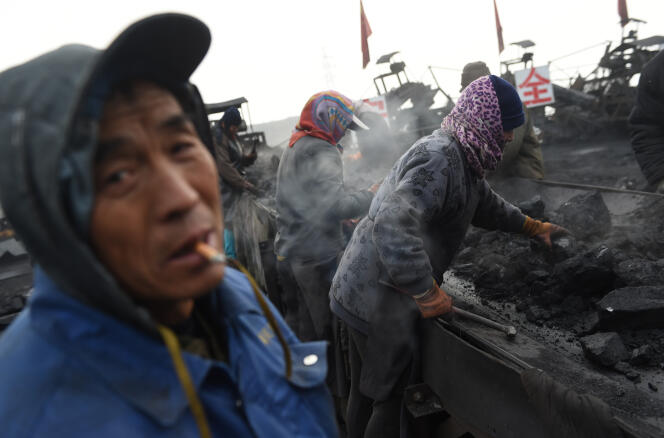 A Datong, des ouvriers trient du charbon sur un tapis roulant.