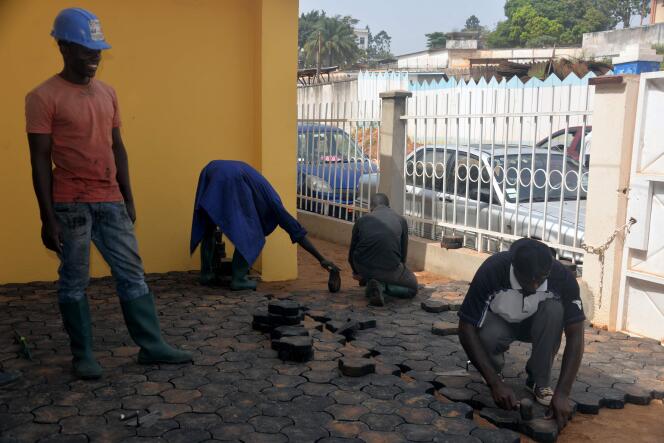 Des Camerounais couvrent le sol de pavés recyclés en déchets plastique à Yaoundé, le 1er février 2016.