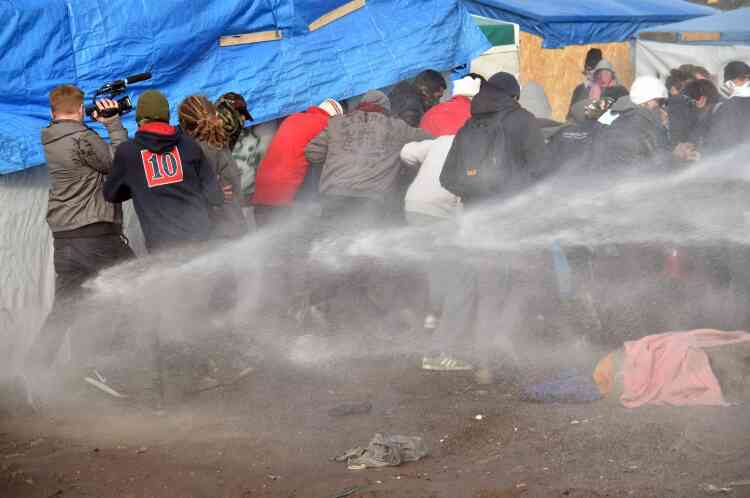 La police tente d'évacuer des migrants à l'aide de lances à incendie, le 29 février.