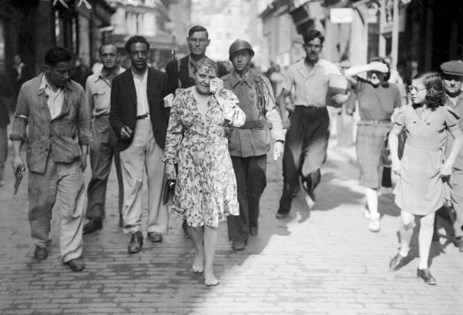 La photo, prise en août 1944, d'une femme accusée d'avoir collaboré avec les Allemands. Elle est obligée de défiler dans la rue, le crâne rasé, pieds nus, une croix gammée sur le front, après la Libération de Paris.
