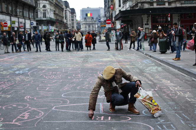 Place de la Bourse à Bruxelles, où les gens on commencé à se recueillir et écrire à la craie sur le sol, des messages de solidarité envers les victimes, mardi 22 mars.