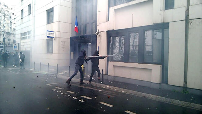 Capture d'écran d'une vidéo montrant des casseurs qui s'en prennent à un commissariat de police à Paris, vendredi 25 mars. AFP / Guillaume Bonnet