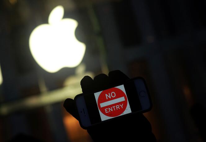 Un manifestant opposé au gouvernement brandit son iPhone avec le signe « Ne pas entrer » lors d'une action près d'un Apple Store à New York, le 23 février 2016.