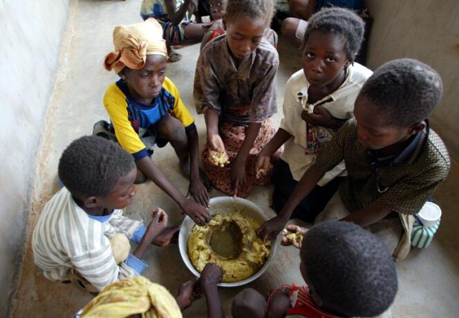Des écoliers prennent leur repas dans la cour de l'école du village de Kokolo, près de Bandiaga. Mali, 2002.